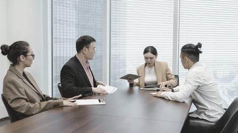 A woman presenting with a tablet in a boardroom